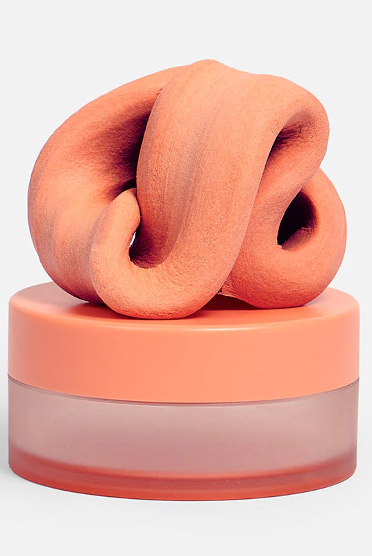 Speks Blur Focus Putty in Clementine inside its frosted plastic storage container