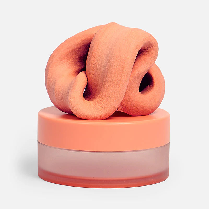Speks Blur Focus Putty in Clementine  inside its frosted plastic storage container