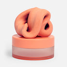 Speks Blur Focus Putty in Clementine  inside its frosted plastic storage container